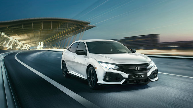 Honda Civic Sport Line in 3/4-Frontansicht bei der Fahrt durch die Stadt.