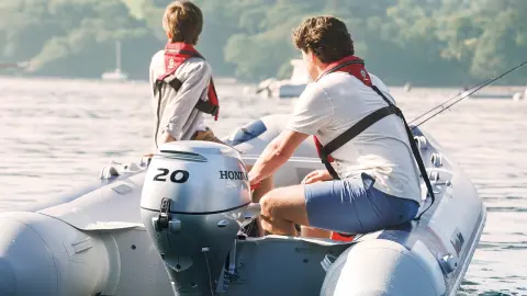 Zwei Männer auf einem Honwave mit BF20-Motor auf einem See.