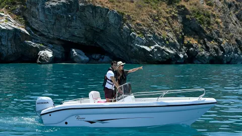 Paar auf einem kleinen Boot mit Honda BF-Motor auf einem See.