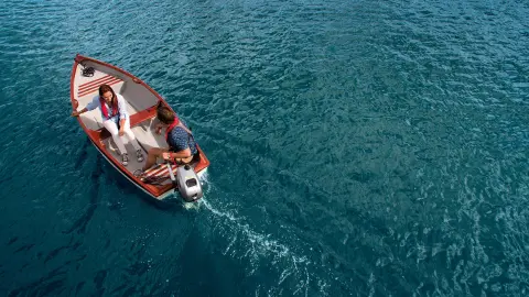 Paar auf einem Boot mit Honda Motor auf dem Wasser.