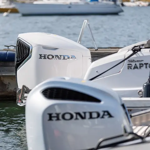 Nahaufnahme von Honda-Motoren an Bootshecks auf dem Wasser. 