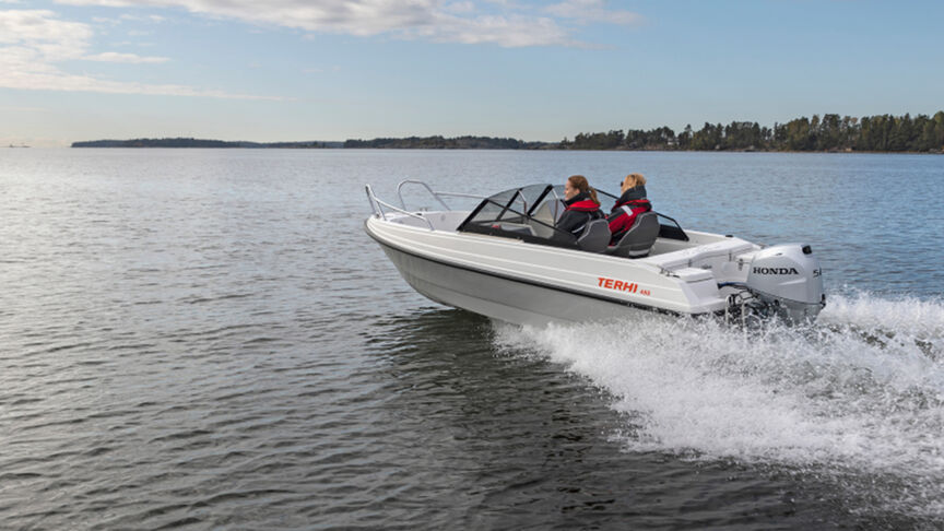 Mann auf einem Boot mit einem B40-Motor an der Küste. 