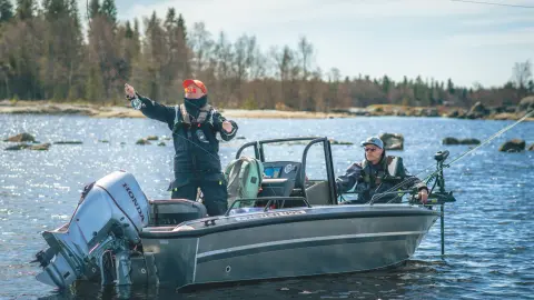 Zwei Herren auf einem Boot mit Honda BF60-Motor beim Angeln in einem See. 