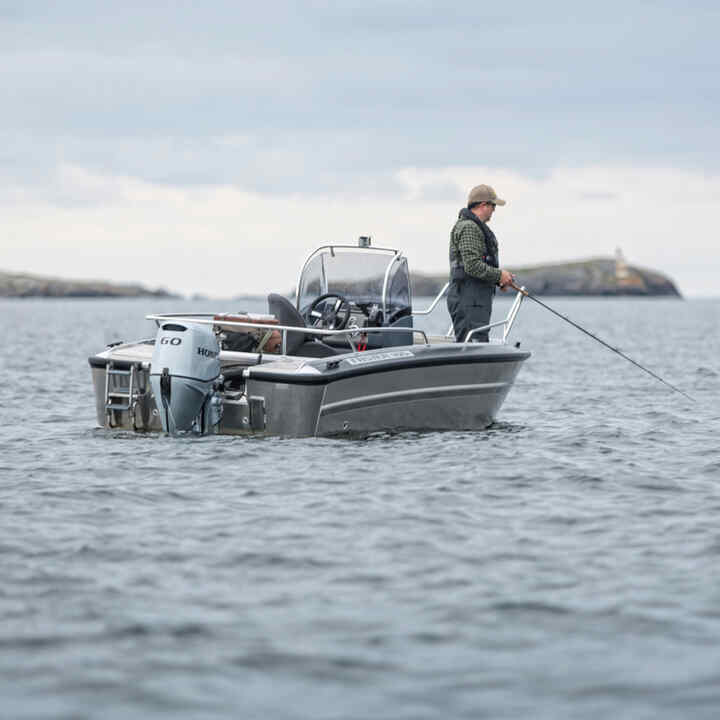 Mann auf einem Boot mit Honda BF60-Motor in maritimer Umgebung. 