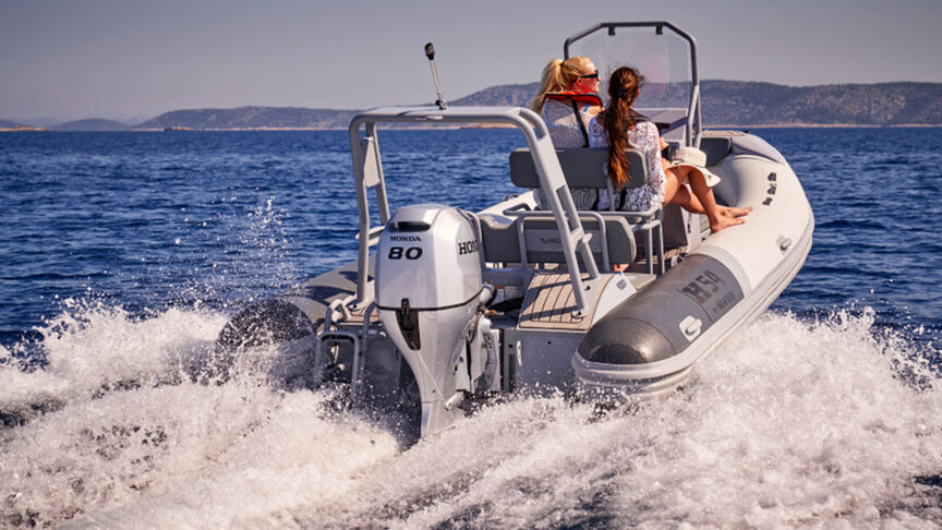 Model, das ein Boot mit BF80-100-Motor über das Meer steuert.