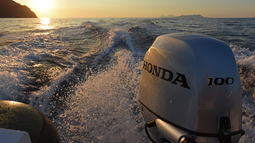 Model, das ein Boot mit BF80-100-Motor über das Meer steuert.