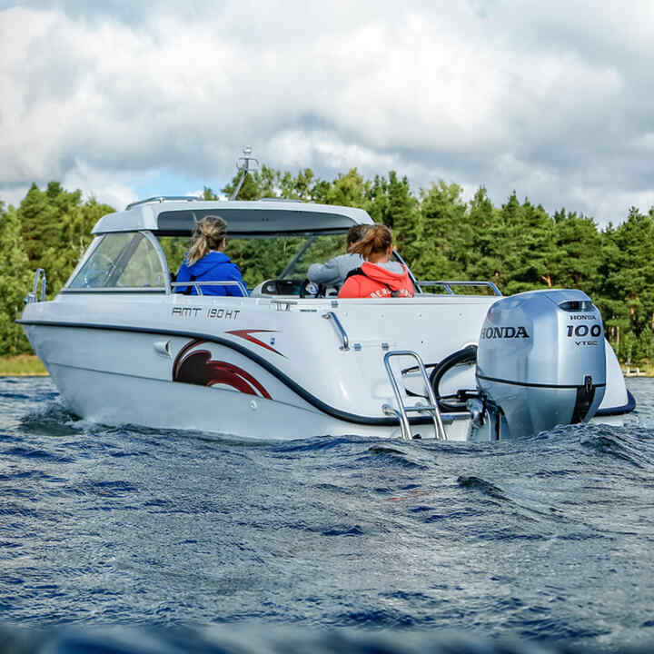 Familie auf einem Boot mit Honda BF80-100-Motor auf einem See. 