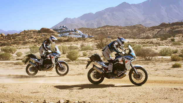 Zwei HAR-Reiter in Marokko mit den bemalten Felsen im Hintergrund