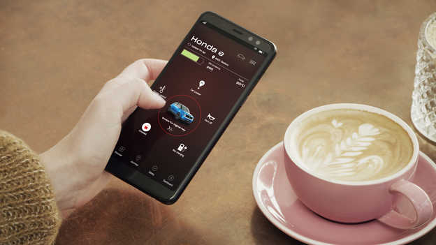 Eine Honda-Besitzerin nutzt die My Honda+ App auf ihrem Telefon.